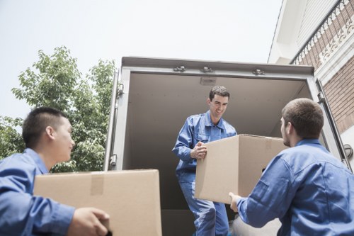 Delivery staff loading items carefully into a van for a local removal job